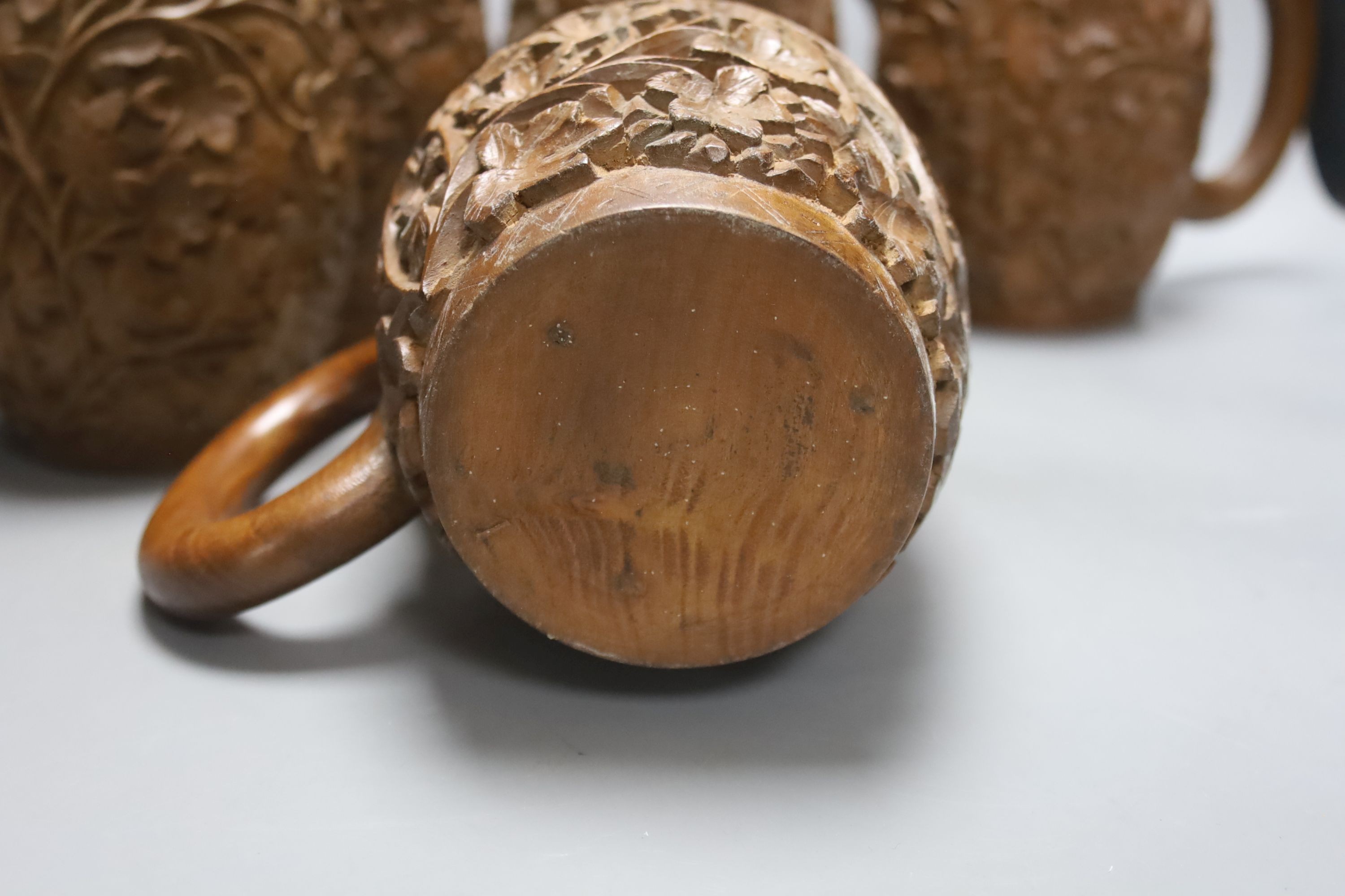 A set of six South Asian carved teak mugs 15.5cm